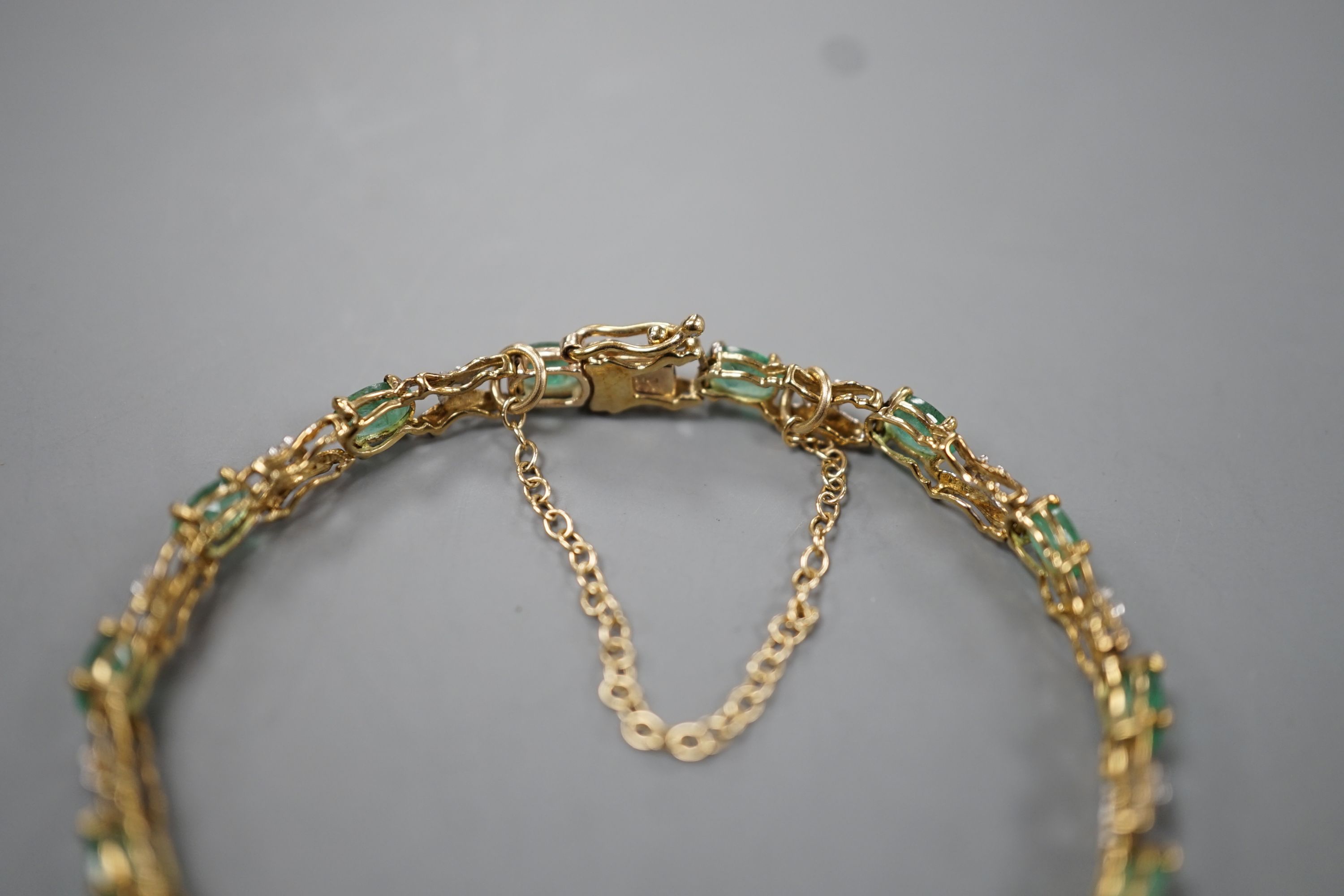 A modern 9ct gold, emerald and diamond chip set line bracelet, approx. 17cm, gross weight 5 grams.